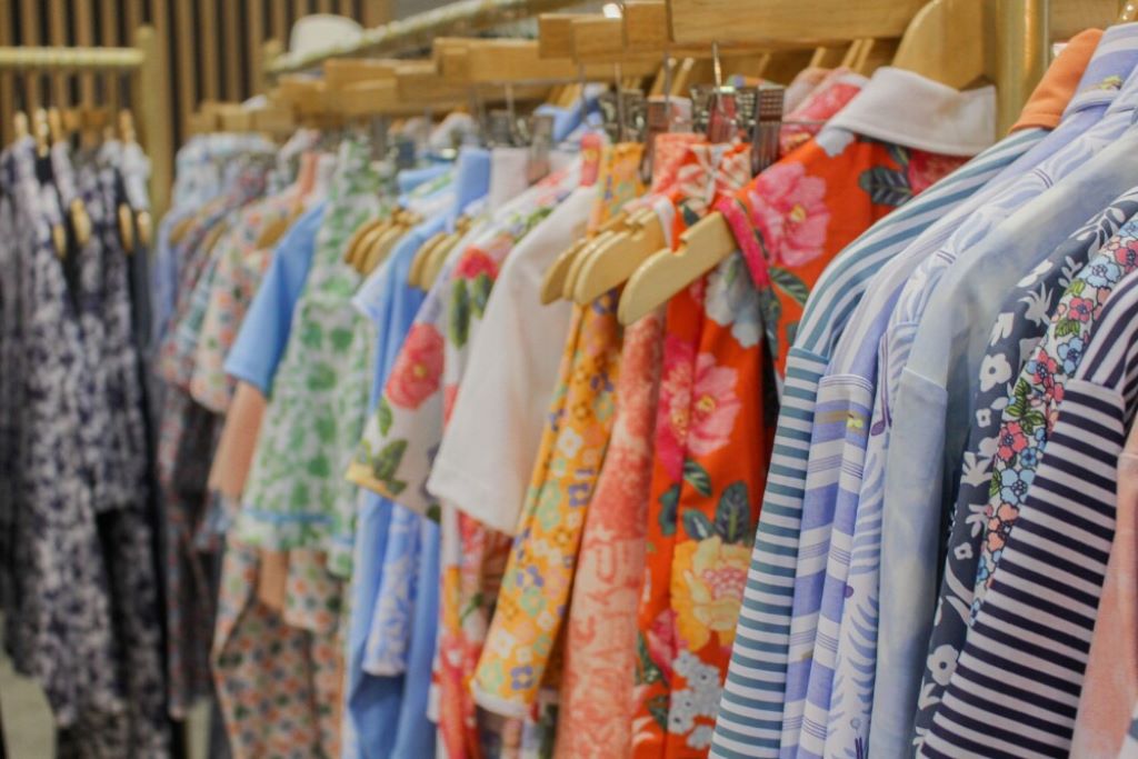 Collection of colorful golf dresses displayed on hangers showing various styles and brands