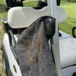 Cleaning a magnetic golf towel magnet with a microfiber cloth